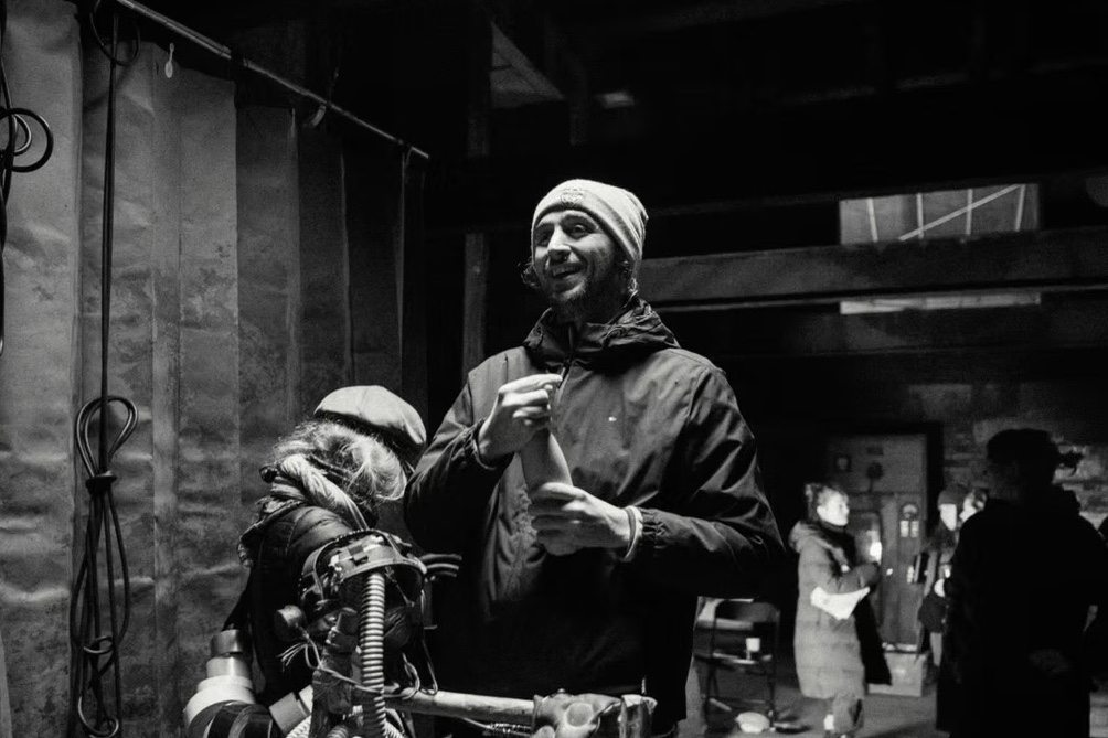 Cameron Richards directing on set, in black and white.