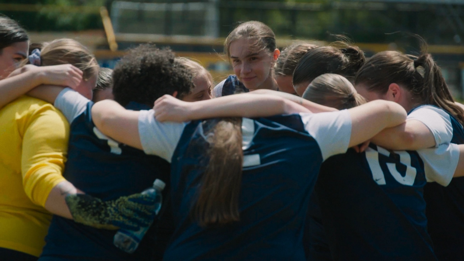 Still from Emily's Last Game: a women's football team in a huddle before a match.
