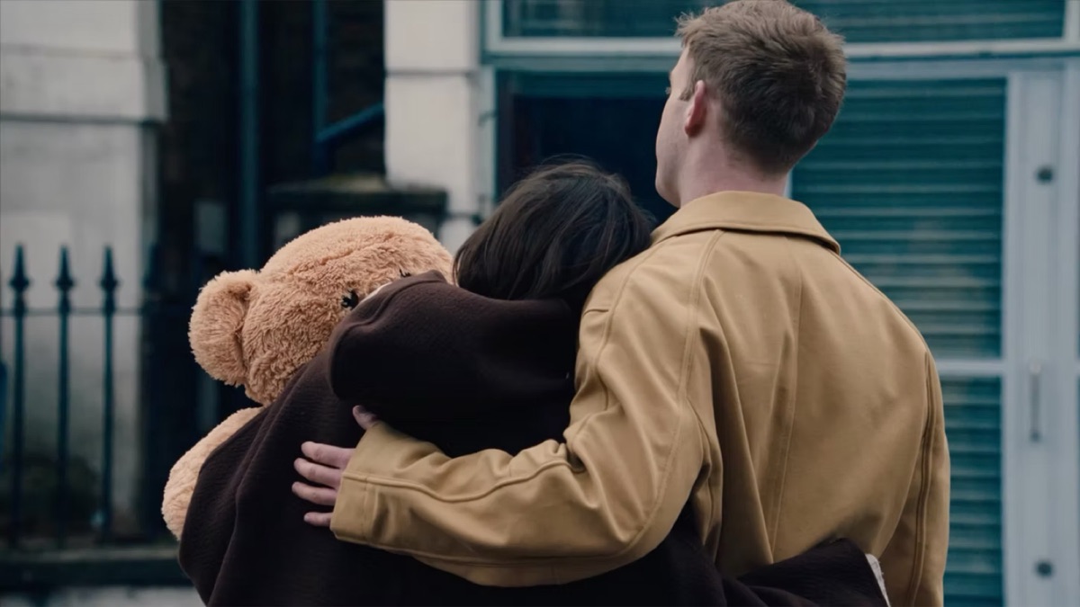 Still from I'm a Good Person: a couple seen from behind, one holding a large teddy bear.