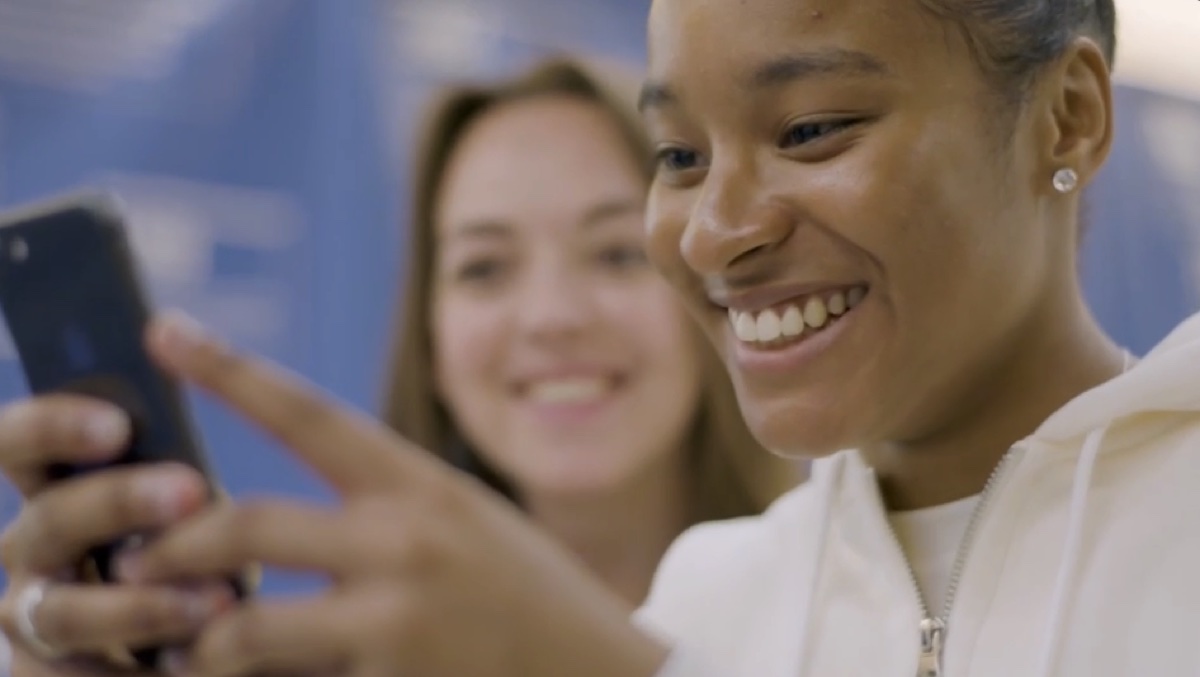 Still from Snap x Design Museum: two visitors smiling at a phone screen.
